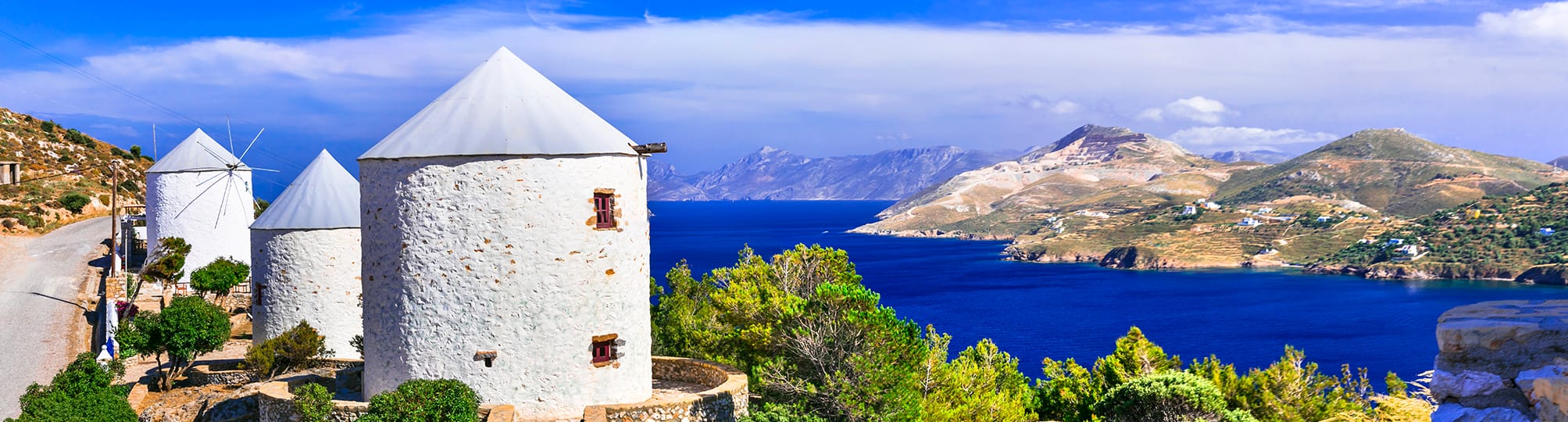 Picturesque view of the Dodecanese Islands sailing itinerary near Agia Marina, Leros, Greece – A yacht anchored in a serene harbor, surrounded by traditional white-washed buildings and lush hills, capturing the charm of this idyllic island destination.