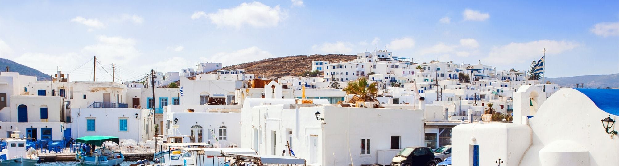 Stunning overview of the Paros two-week Cyclades sailing itinerary – A yacht navigating the crystal-clear waters of the Aegean Sea, with the beautiful islands of the Cyclades in the background, showcasing the region's breathtaking scenery and coastal charm.